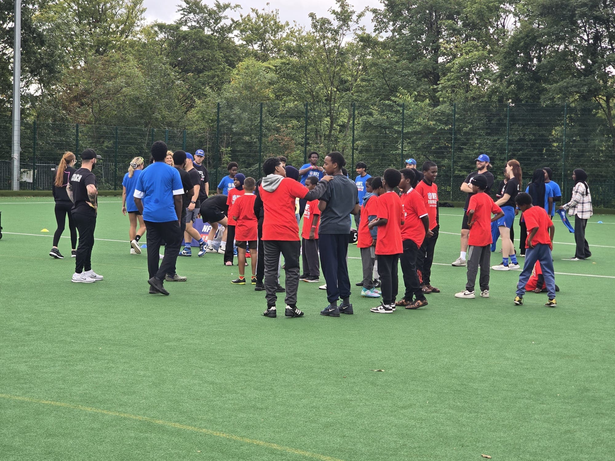 Coaches and young people at a BSCA flag football session on an astroturf pitch